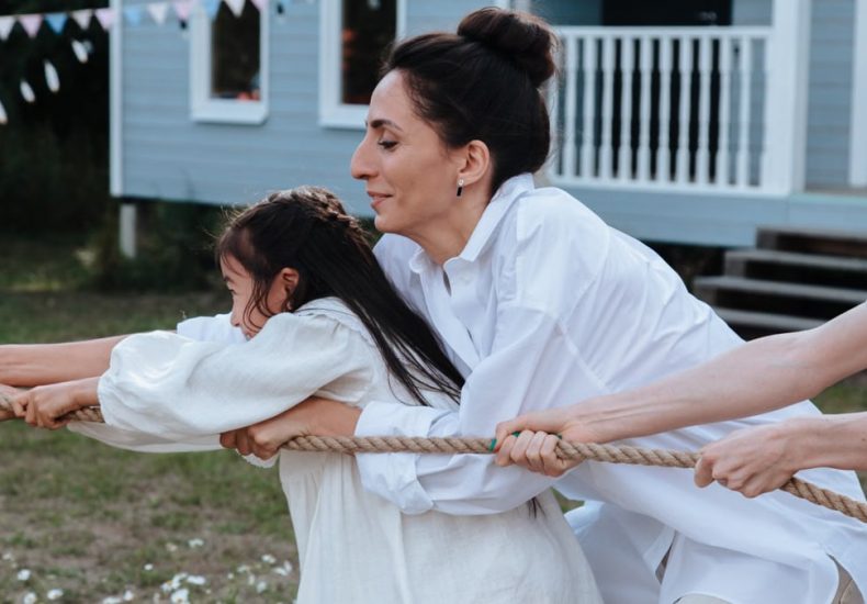 Family enjoying a playful tug of war game outdoors, showcasing teamwork and fun.